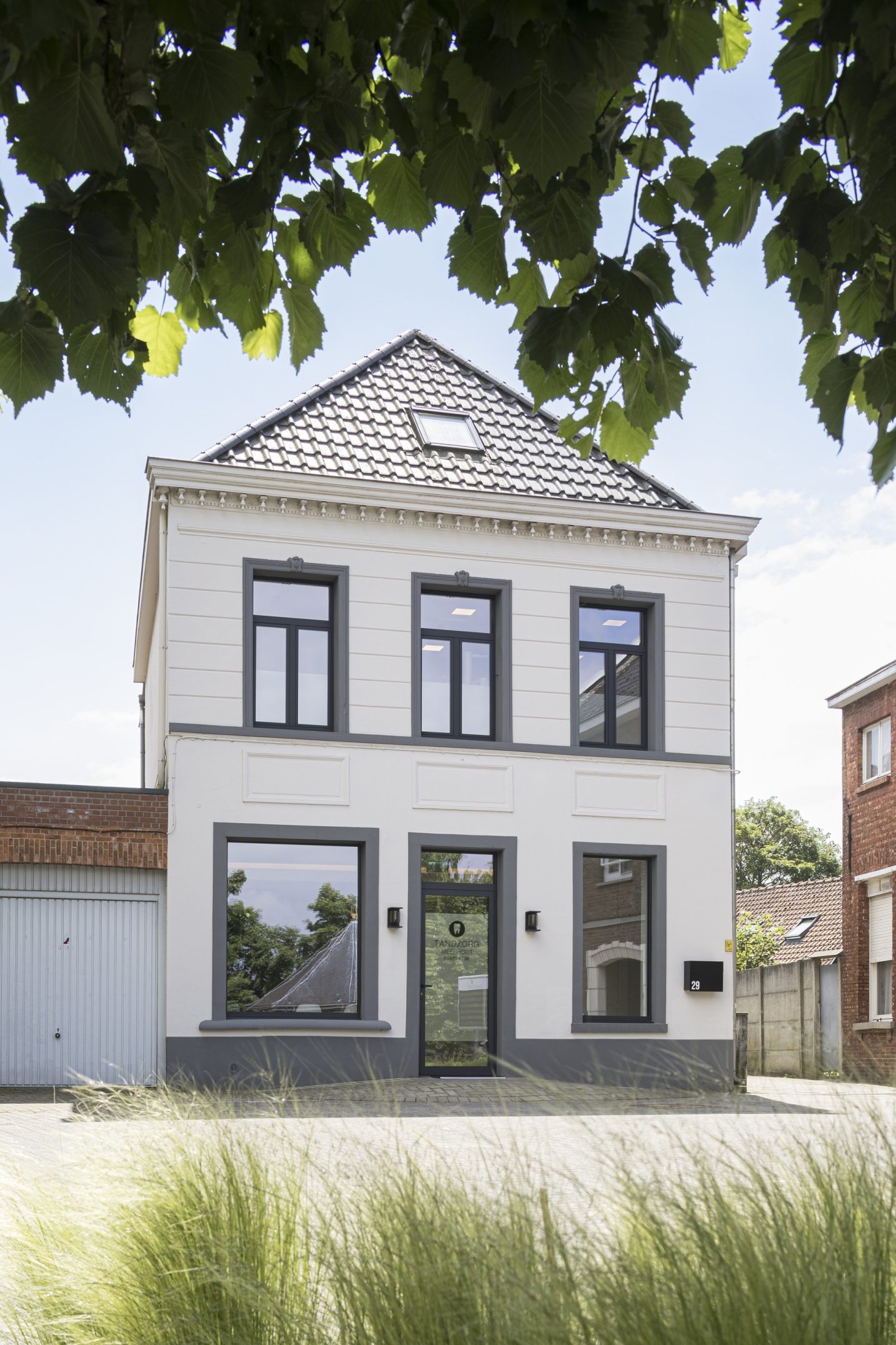 Rustgevende inkomruimte voor tandartspraktijk met warme materialisatie – SFAR interieur & architecten Limburg