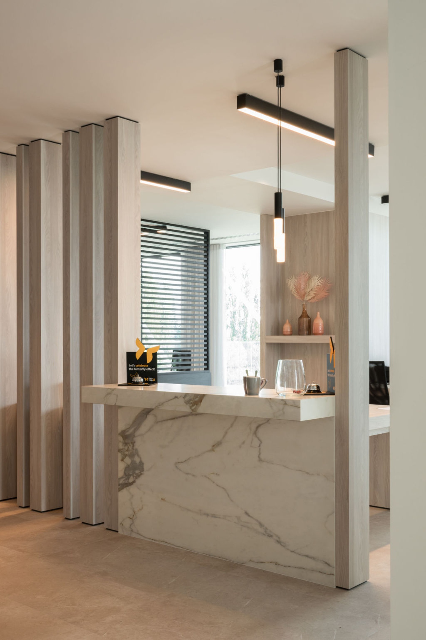 Ontvangstruimte waar natuursteen en hout een elegant contrast vormen – SFAR interieur & architecten Hasselt