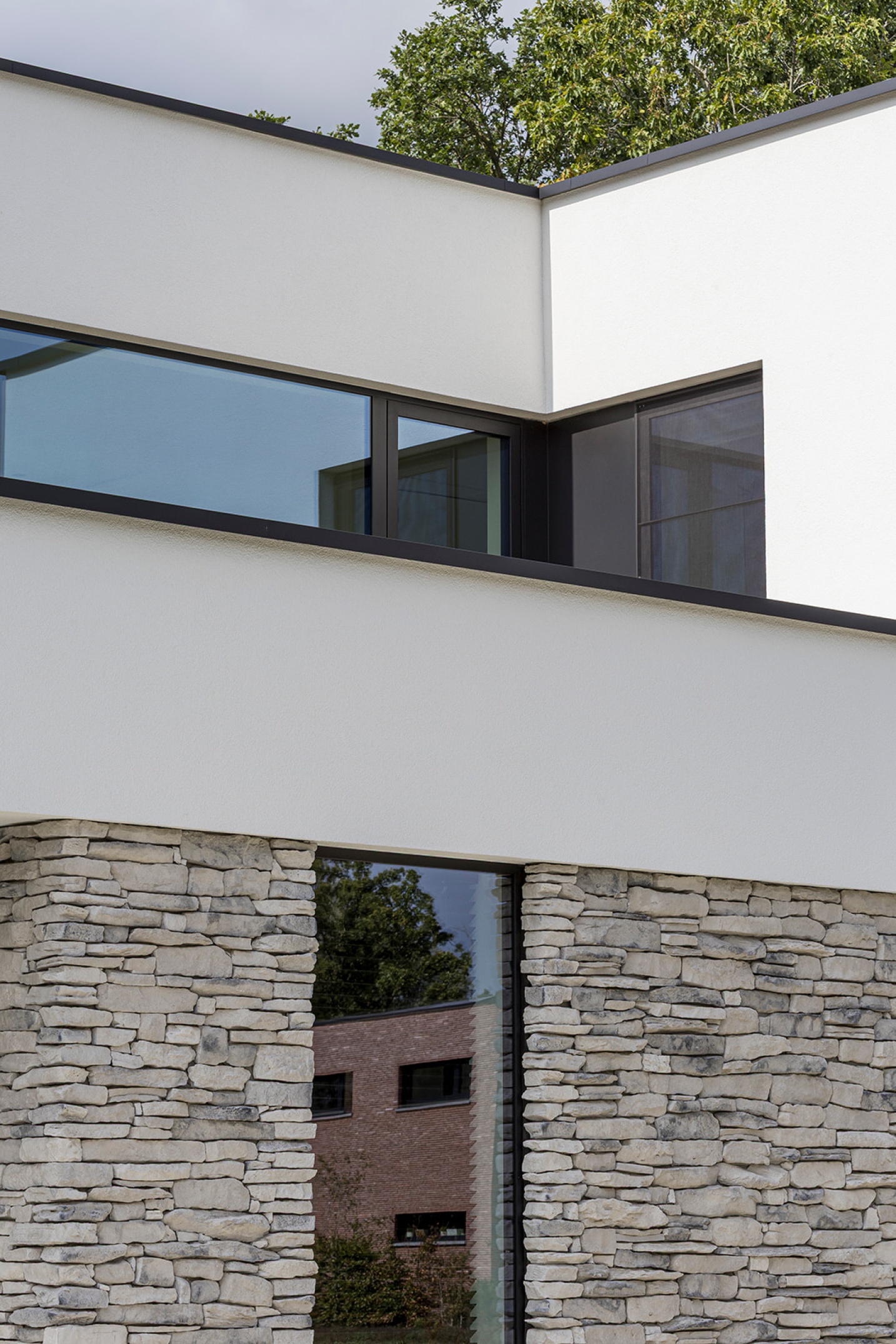 Minimalistische gevel met subtiele detaillering en natuurlijke materialen – SFAR interieur & architecten Limburg
