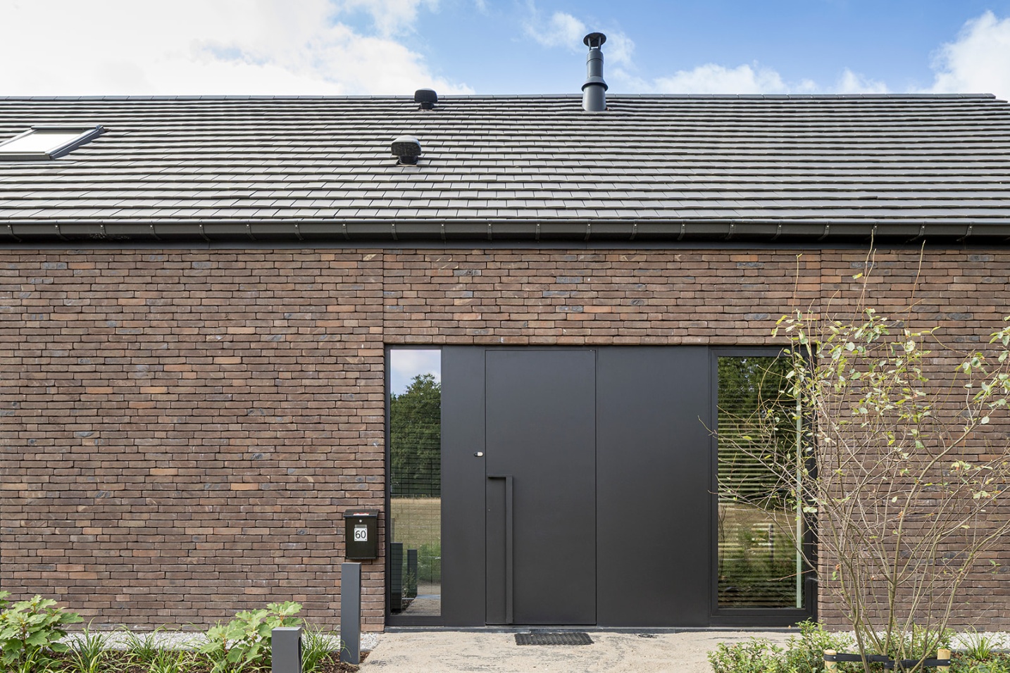 voorgevel modern aluminium beeld donkere steen tijdloos ontwerp mooie woning